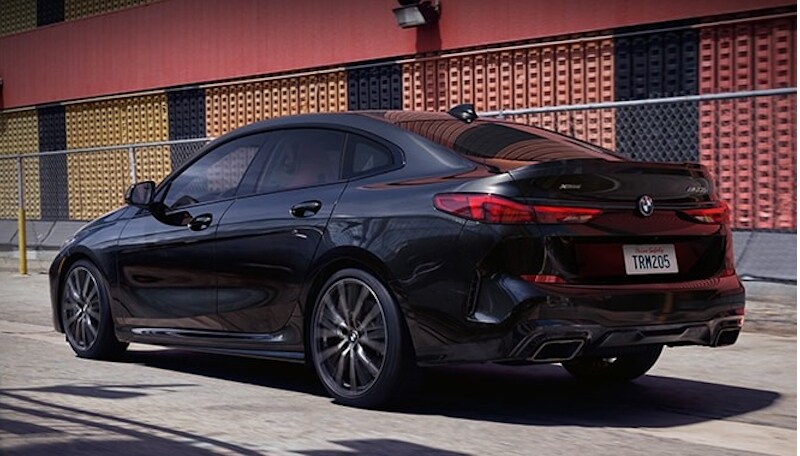 Black Block.jpg A black sapphire metallic BMW 2 Series Gran Coupe driving
past a red and yellow building.