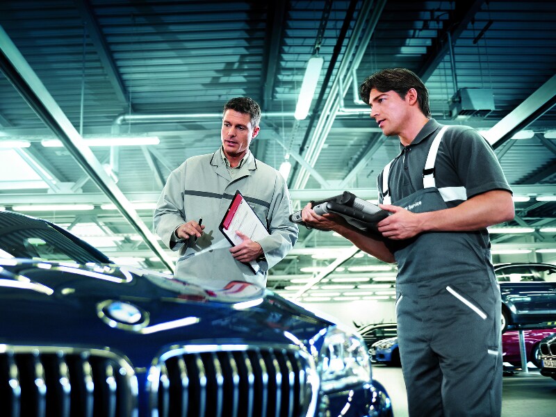 BMW Lease Return - BMW of Sherman Oaks Two service technicians inspecting a BMW car.