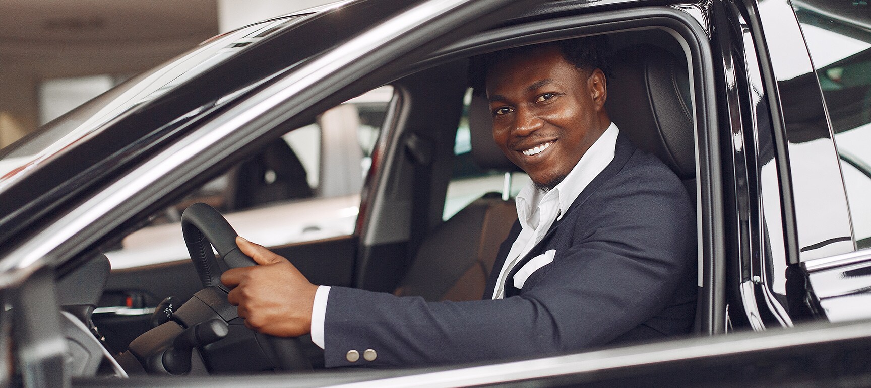 BMW of Towson is a BMW Dealership near Baldwin MD | Well-dressed man sitting in car in dealer showroom