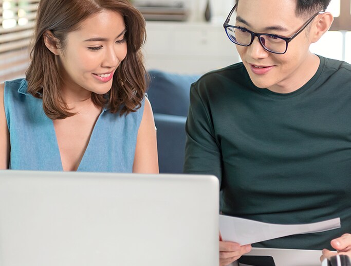 Vehicle Warranty Information at Bobby Rahal Acura in Mechanicsburg, PA | Couple looking at computer screen and paperwork happily