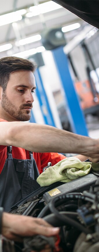 Vehicle Warranty Information at Bobby Rahal Acura in Mechanicsburg, PA | Mechanic in red shirt working under the hood of car