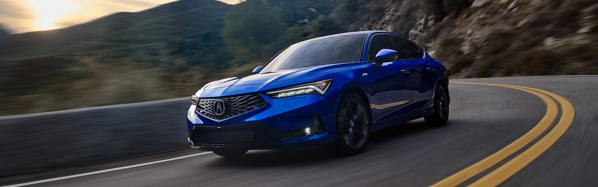 All-New 2023 Acura Integra at Bobby Rahal Acura | Blue 2023 Acura Integra Driving Around Bend with Mountains at Sunset in the Background