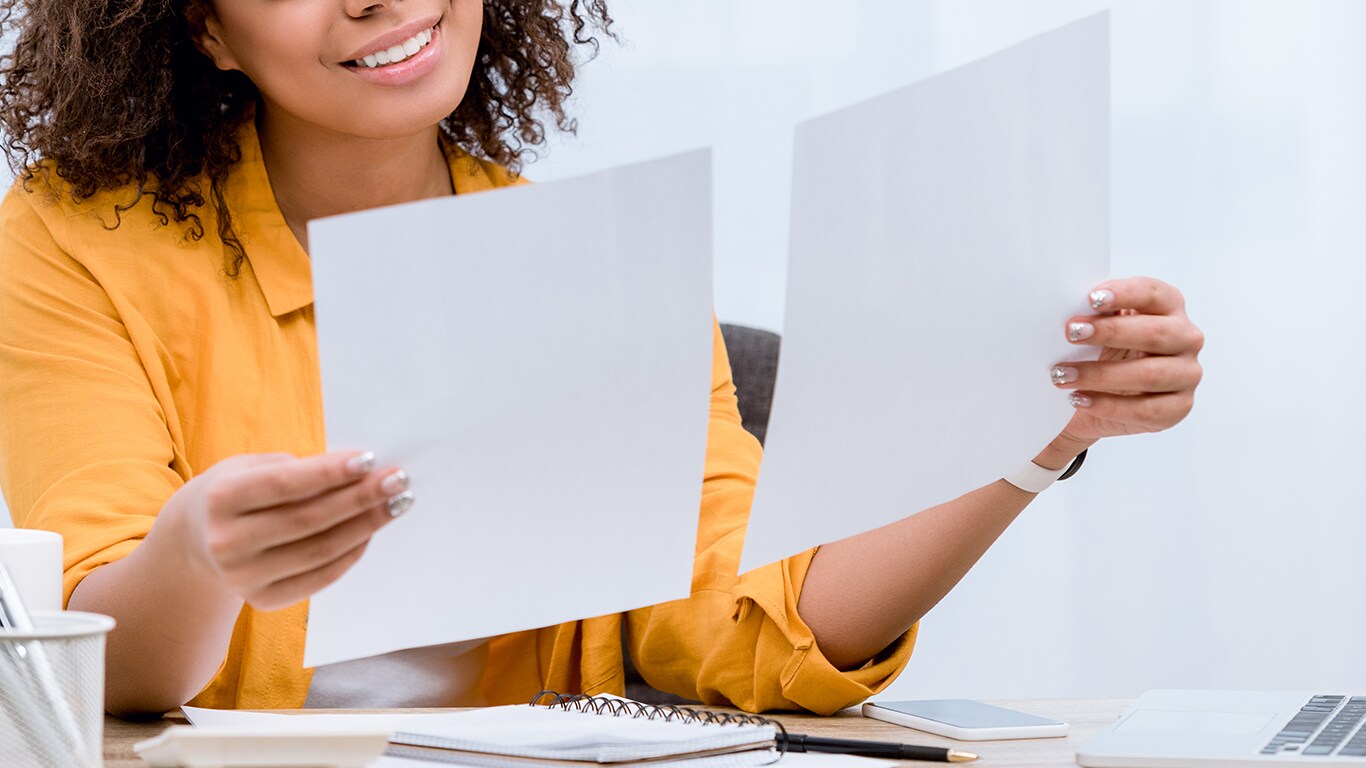 Things to Bring with you to Purchase a Car at Bobby Rahal Acura in Mechanicsburg, PA | Woman holding up her paperwork in each hand