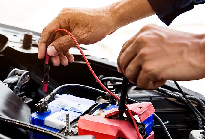 How to Get Your Car Summer Ready at Bobby Rahal Acura in Mechanicsburg, PA | Man testing out battery life with battery checker