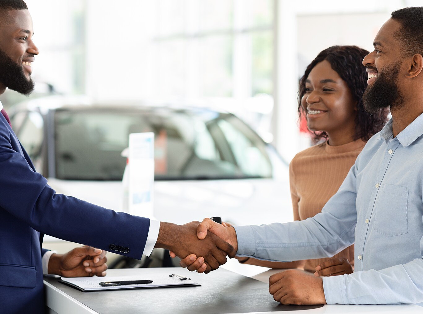 Things to Bring with you to Purchase a Car at Bobby Rahal Acura in Mechanicsburg, PA | Man shaking hands with another man with girlfriend