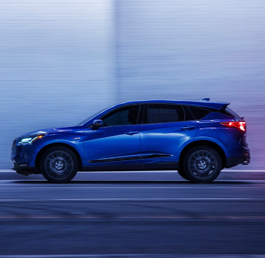 New 2023 Acura RDX at Bobby Rahal Acura | Side view of a Blue Acura RDX driving down tunnel highway at night