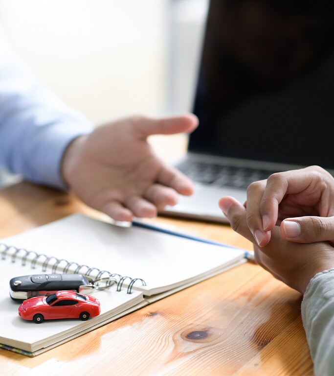 Vehicle Warranty Information at Bobby Rahal Acura in Mechanicsburg, PA | Two people talking about finalizing paperwork for new car
