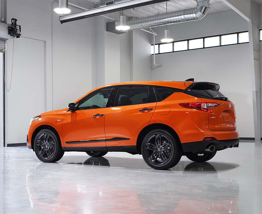 Compare the 2021 Acura RDX vs. the 2022 Audi Q5 at Bobby Rahal Acura | Orange 2021 Acura RDX Parked in Brightly Lit Garage
