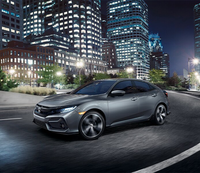 Bobby Rahal Honda is a Car Dealership near Lewisberry PA | Silver Honda Civic Hatchback Driving Through City at Night