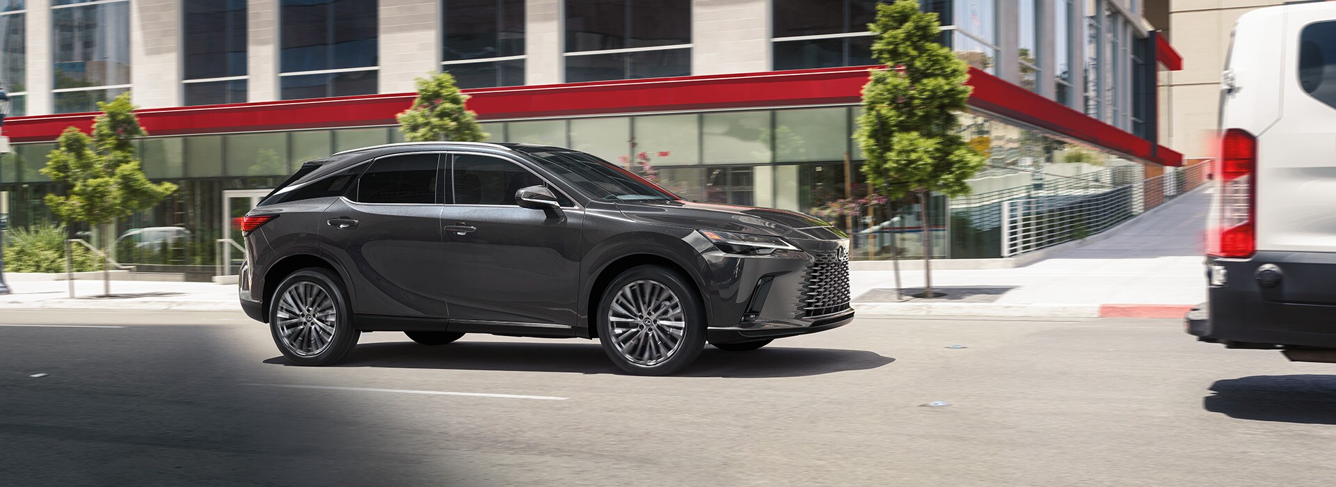 Lexus Dealer near Denver, PA | Dark Gray 2023 Lexus RX Driving Through City Streets