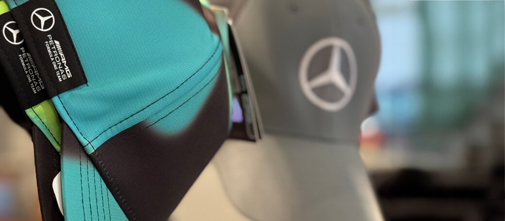 Mercedes-Benz hats in beige black and green displayed on glass shelves