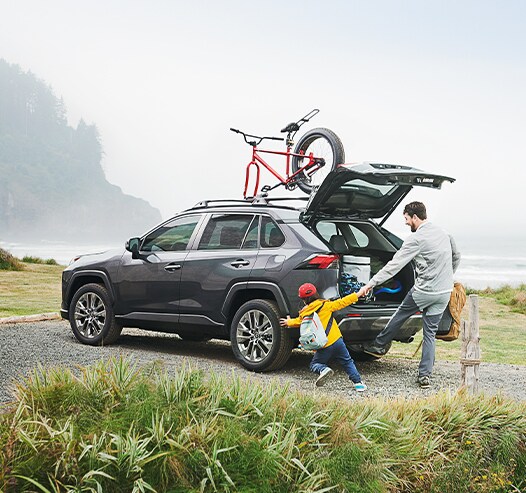 Compare the 2021 Toyota RAV4 vs. the 2021 Subaru Forester at Bobby Rahal Toyota of Mechanicsburg | RAV4 loaded up with hiking gear on hill trail