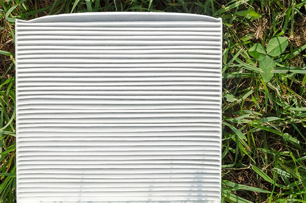 Cabin air filter replacement at Bobby Rahal Toyota | New clean cabi air filter on top of grass