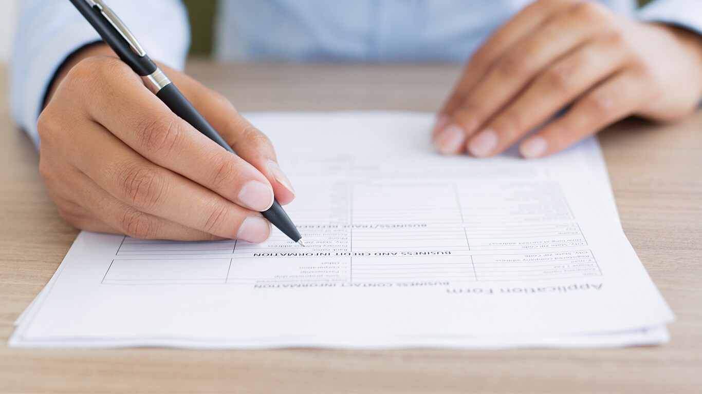 Things to Bring with you to Purchase a Car at Bobby Rahal Toyota in Mechanicsburg, PA | Man signing paperwork with pen