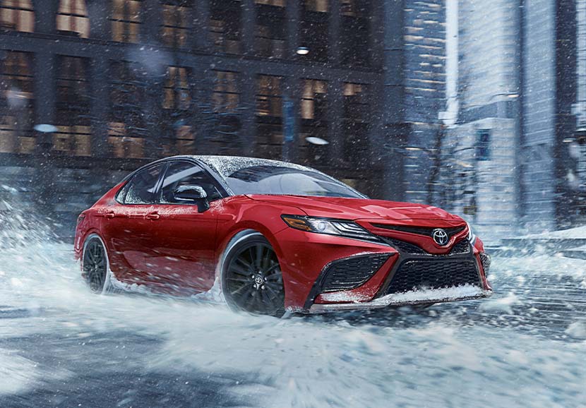 Model Features of the 2022 Toyota Camry at Bobby Rahal Toyota | Red 2022 Toyota Camry All-Wheel Drive Driving in Snowy Weather Through City