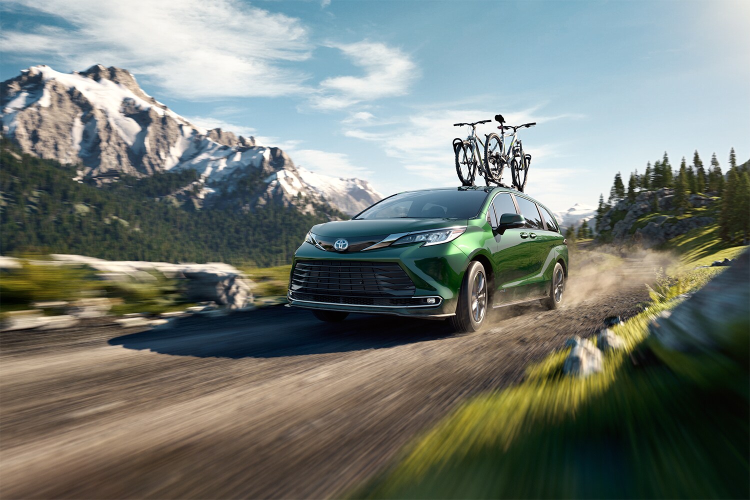 Toyota Hybrid for Everyone at Bobby Rahal Toyota | 2022 Toyota Sienna Hybrid driving on dirt road with bikes on top