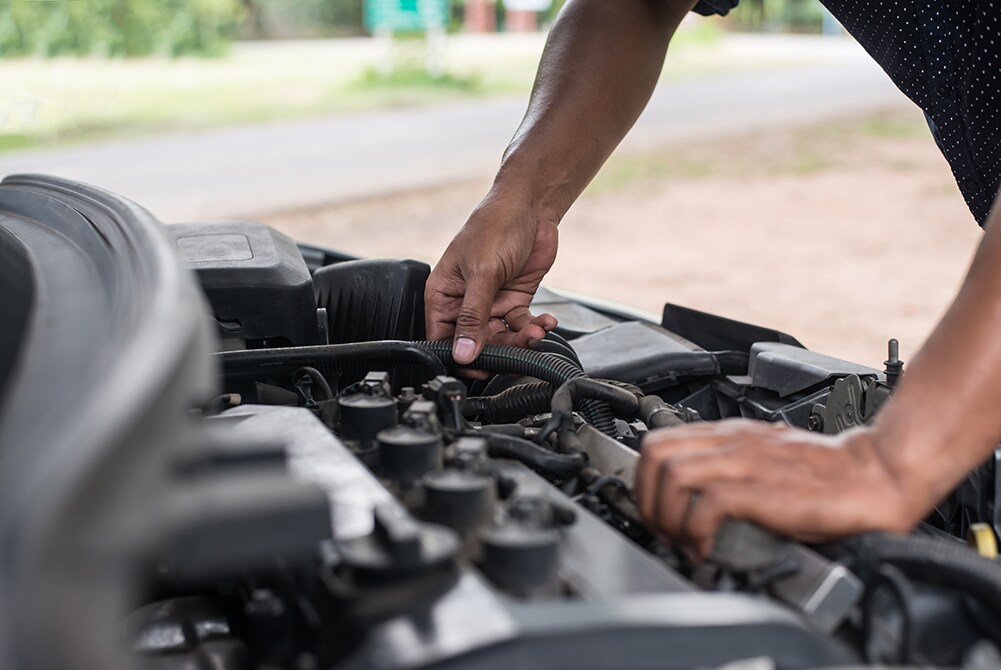 How to prepare your Toyota for the winter season in Mechanicsburg, PA at Bobby Rahal Toyota | Man checking his hoses in his car to make sure they are good before winter