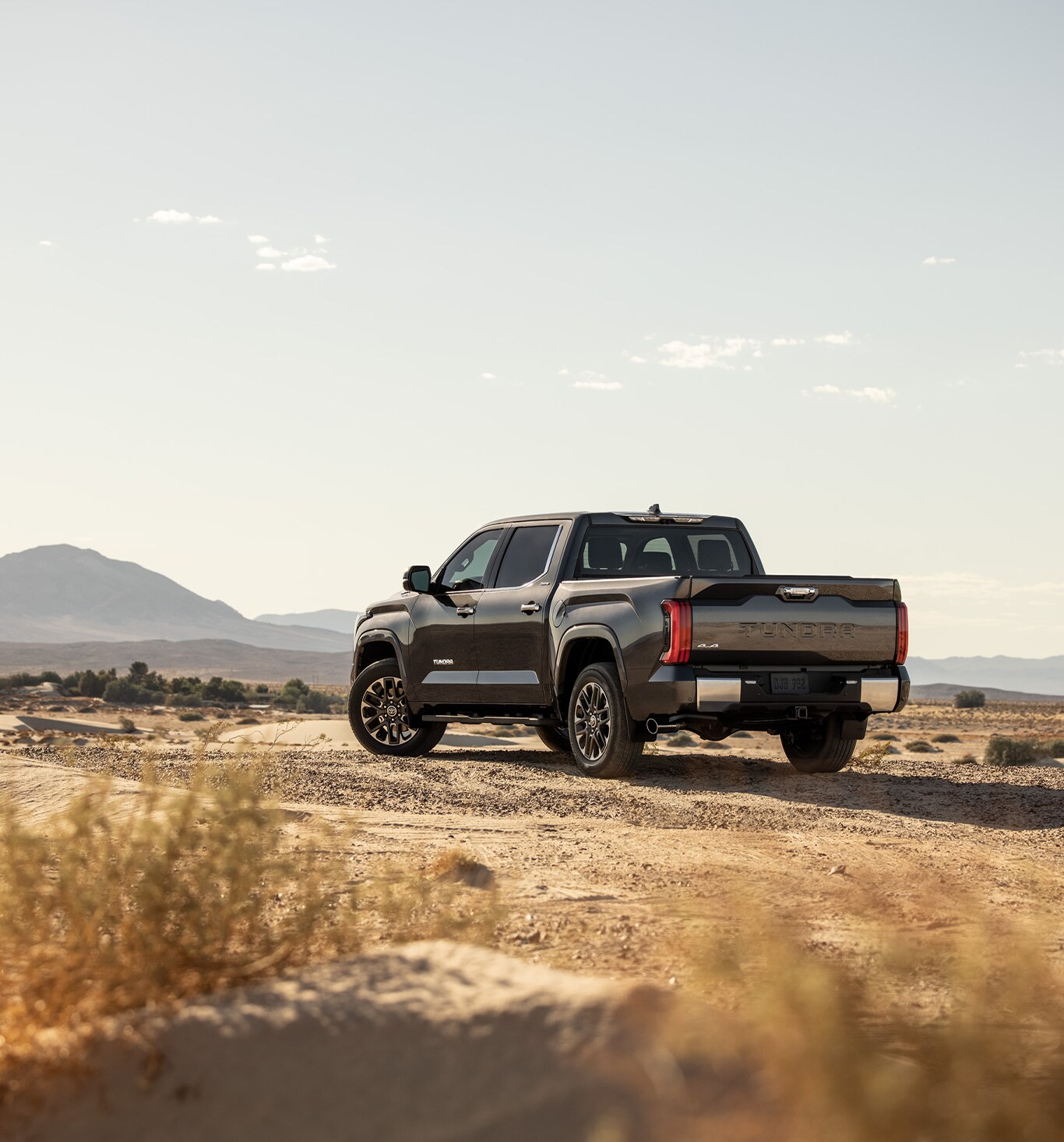 2023 Toyota Tundra vs. 2023 Ford F-150 at Bobby Rahal Toyota | Rear view of a black Toyota Tundra parked in the middle of a dirt road