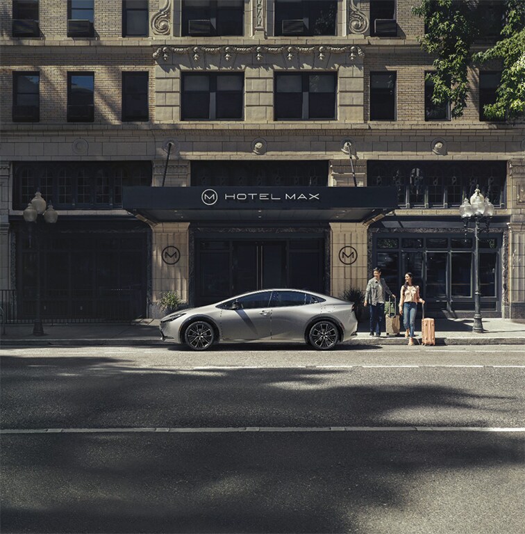 2023 Toyota Prius at Bobby Rahal Toyota in Mechanicsburg, PA | Side profile of a silver 2023 Toyota Prius in the color silver parked outside of a hotel