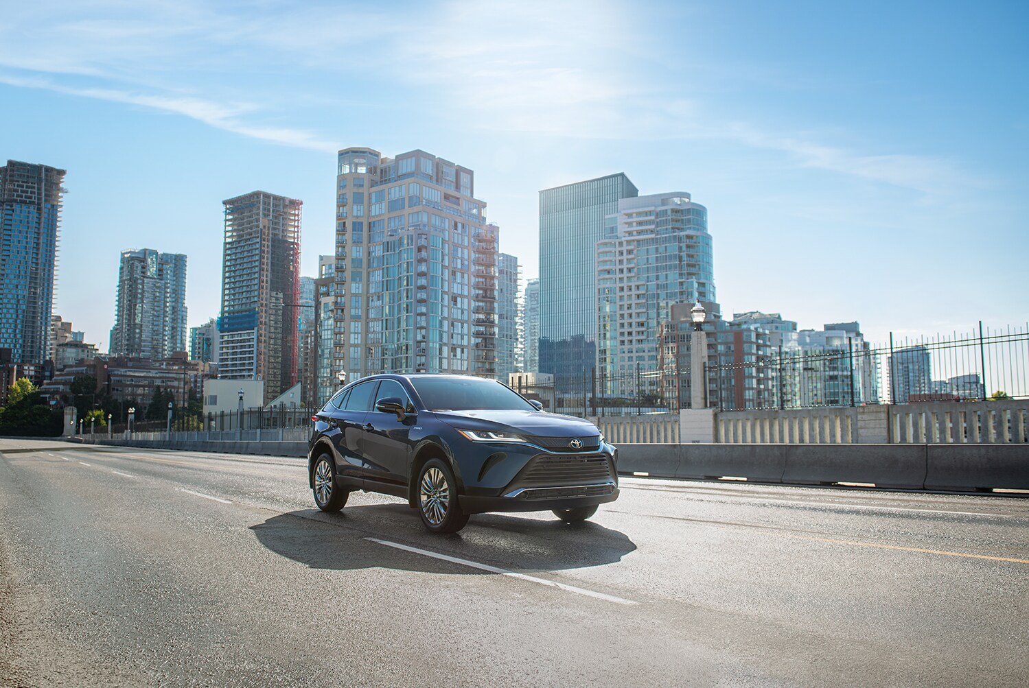Toyota Hybrid for Everyone at Bobby Rahal Toyota | 2021 Toyota Venza driving over a bridge with a city in the background
