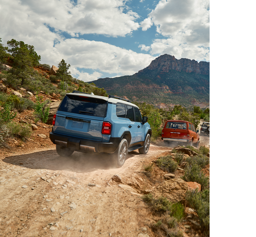 2024 Toyota Land Cruiser at Bobby Rahal Toyota in Mechanicsburg, PA | Rear profile of a 2024 Toyota Land Cruiser driving down a dirt road