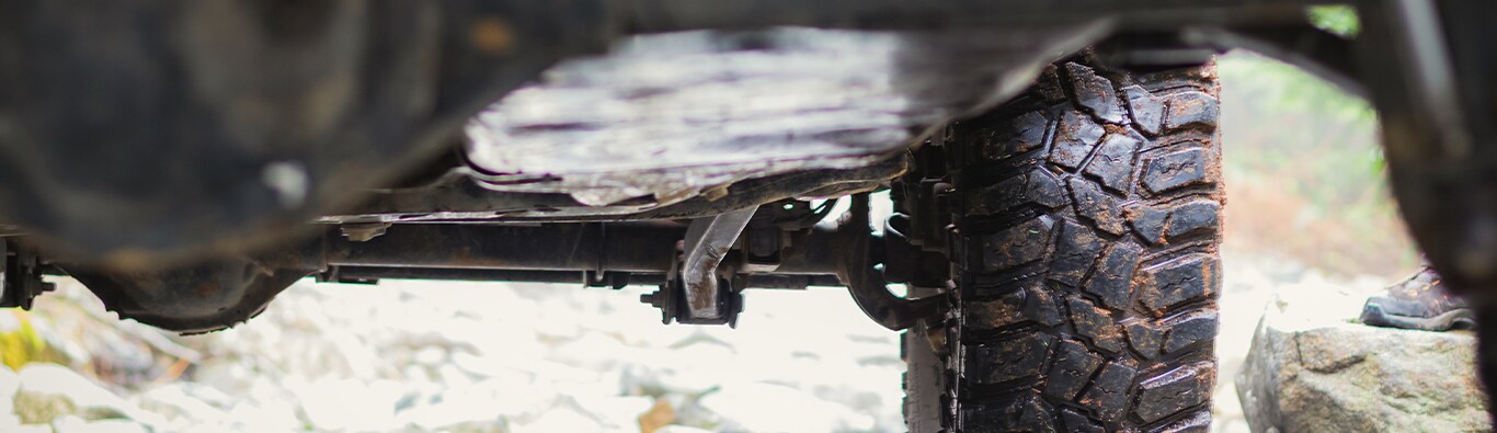 What is Tire and Rim Protection? | Bobby Rahal Toyota | View of the bottom of a truck with a-lot of dirt and debris all around the tires and metal