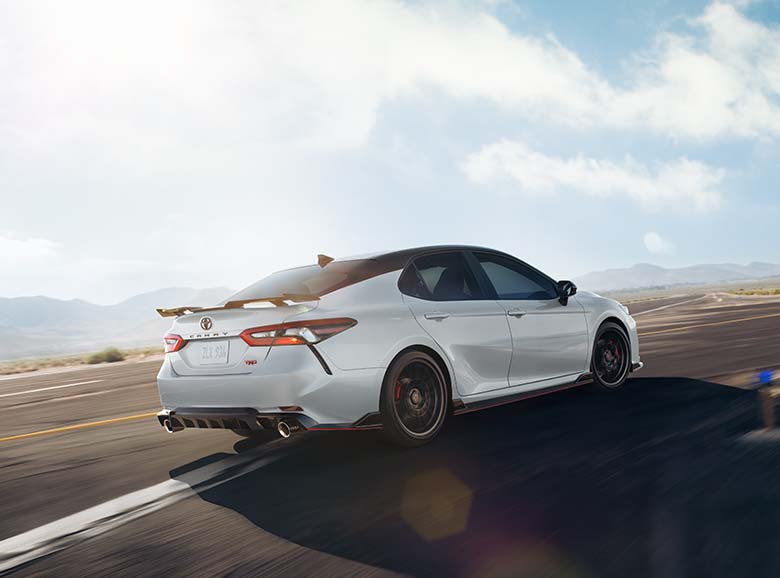 Model Features of the 2022 Toyota Camry at Bobby Rahal Toyota | White 2022 Toyota Camry TRD Pro Driving Around Bend on Track