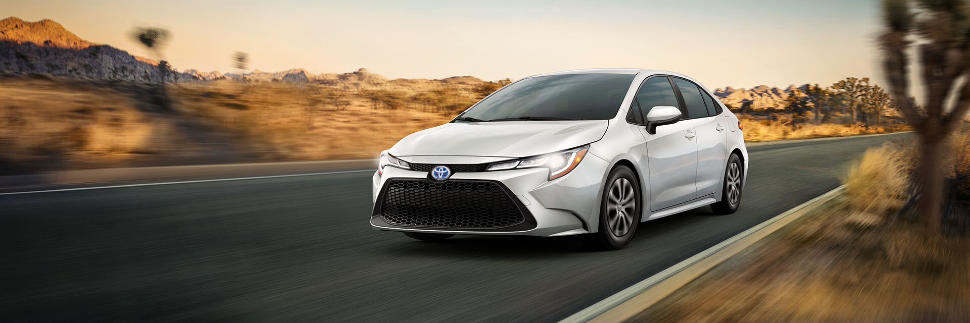 Leasing versus Buying a Toyota at Bobby Rahal Toyota in Mechanicsburg, PA | Front View of Silver 2022 Toyota Corolla-Hybrid Front Driving Fast Through Desert