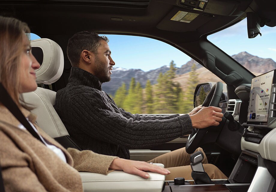 Model Features of the All-New 2023 Toyota Sequoia at Bobby Rahal Toyota | Passenger Window View of Couple Driving 2023 Toyota Sequioa in Woodland Area