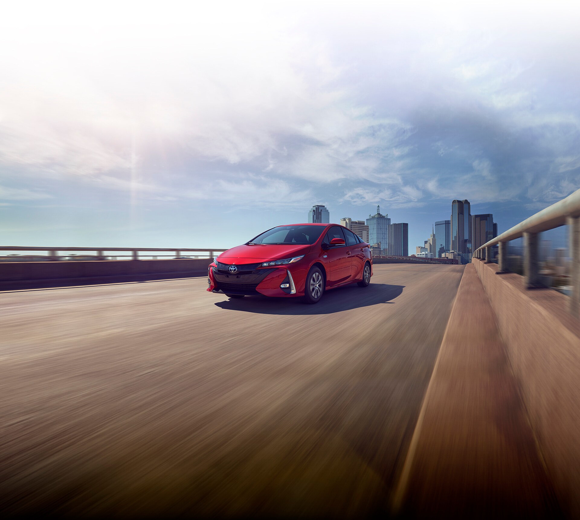 Bobby Rahal Toyota is a Car Dealership near Dillsburg PA | 2021 Toyota Prius Prime driving with city in distance