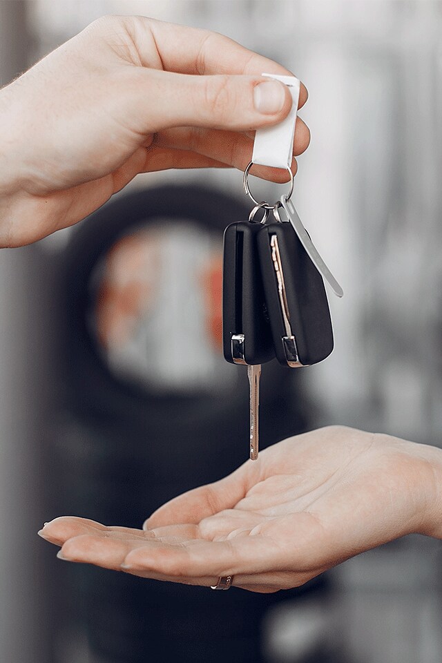 High Cost of Replacing a Car Key | Bobby Rahal Toyota | Hand Holding Keys Passing them to Another Hand Held Out Underneath the Keys