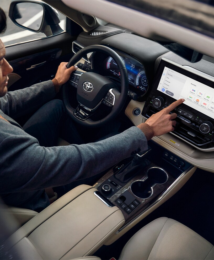 2023 Toyota Highlander at Bobby Rahal Toyota in Mechanicsburg, PA | Man siting in the drivers seat while holding on to the steering wheel of a 2023 Toyota Highlander