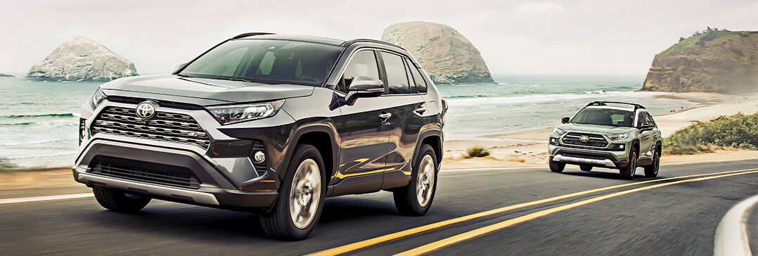 Compare the 2021 Toyota RAV4 vs. the 2021 Subaru Forester at Bobby Rahal Toyota of Mechanicsburg | Two RAV4's driving on beach road