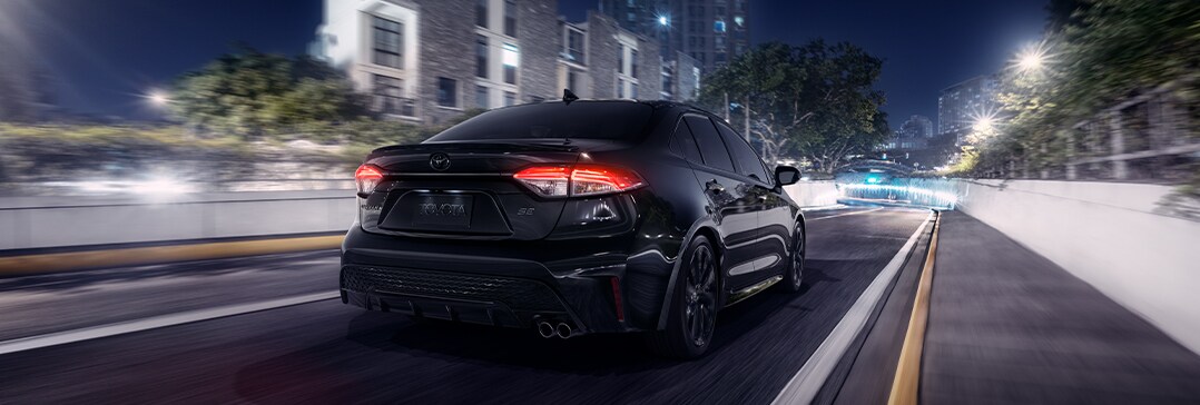 Compare the 2022 Toyota Corolla vs. the 2021 Subaru Impreza at Bobby Rahal Toyota | Corolla driving away downtown at night