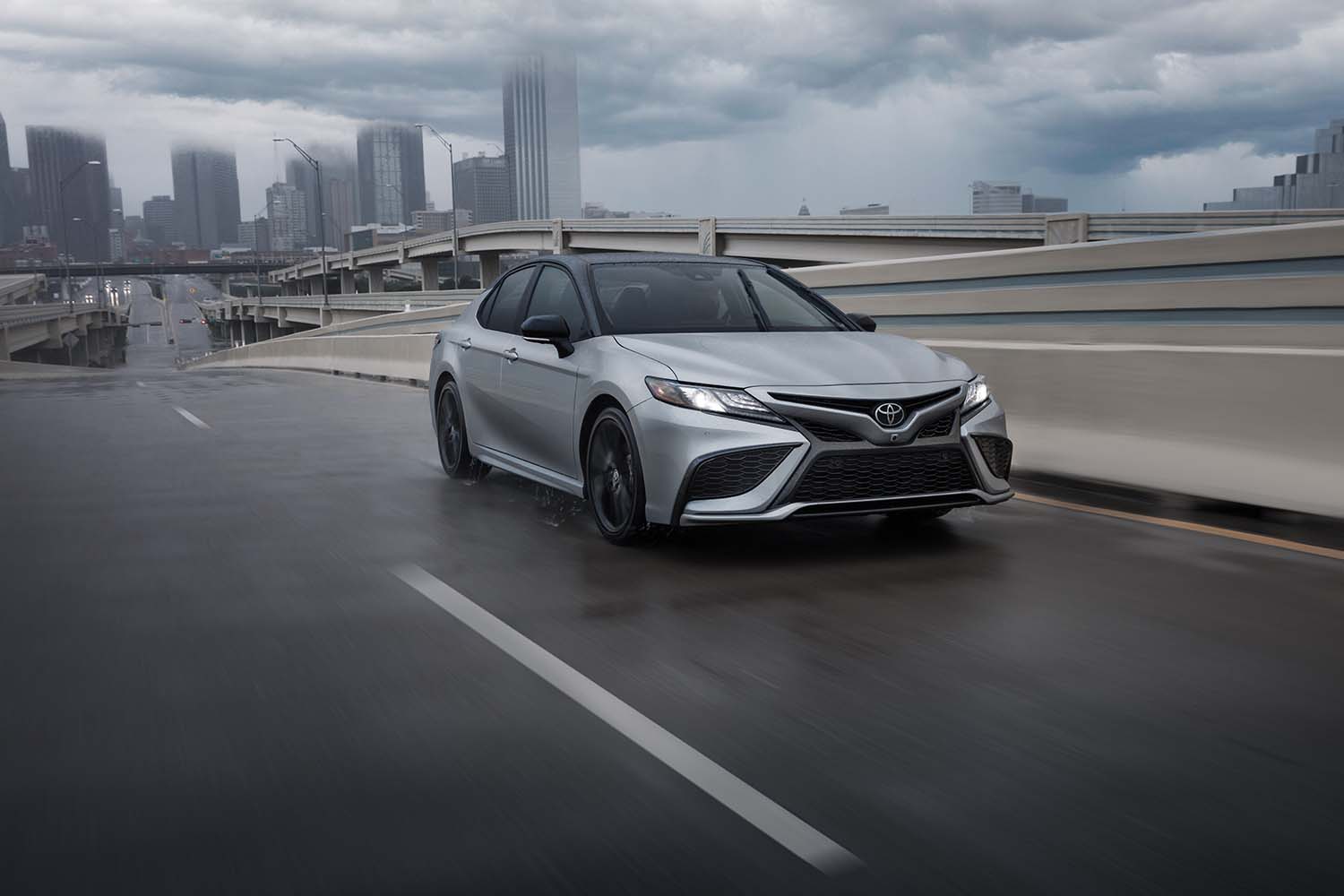 The All-New 2022 Toyota Camry at Bobby Rahal Toyota in Mechanicsburg, PA | 2022 Toyota Camry driving on a bridge in rainy weather