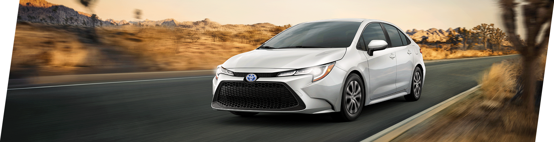 Tips for spring cleaning your car at Bobby Rahal Toyota in Mechanicsburg, PA | 2022 White Toyota Corolla Hybrid Facing Left Driving Through Desert