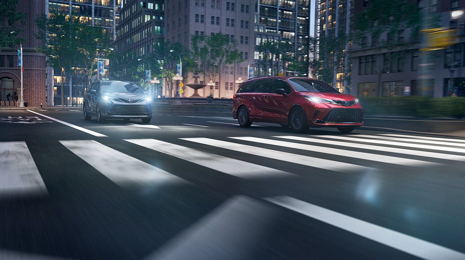 Toyota Hybrid for Everyone at Bobby Rahal Toyota | Two 2022 Toyota Sienna Hybrids driving down the road together at night