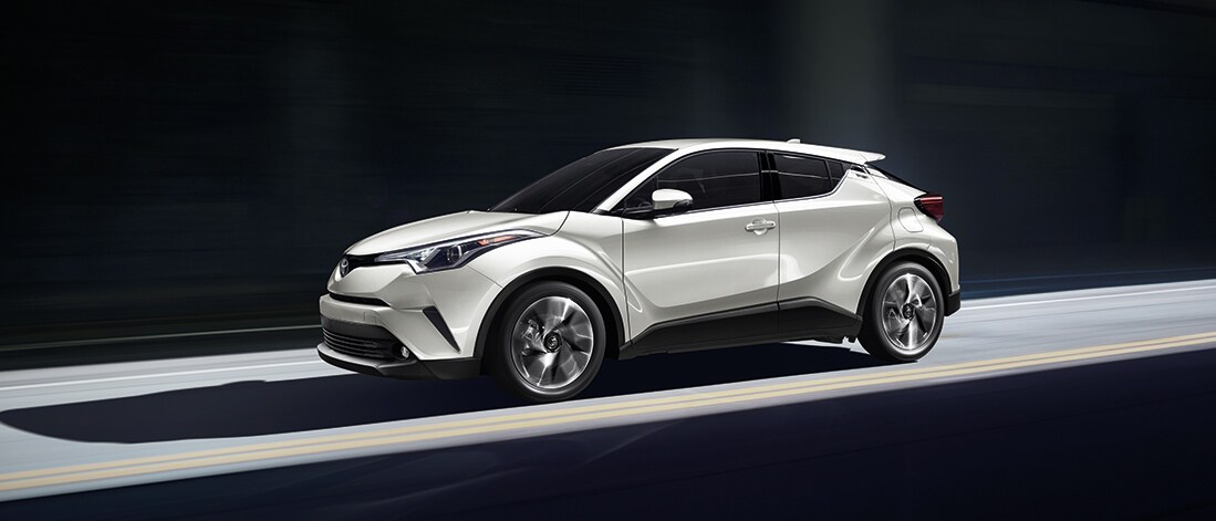CHRMY19_Header_WhiteL.jpg White C-HR driving fast down a road