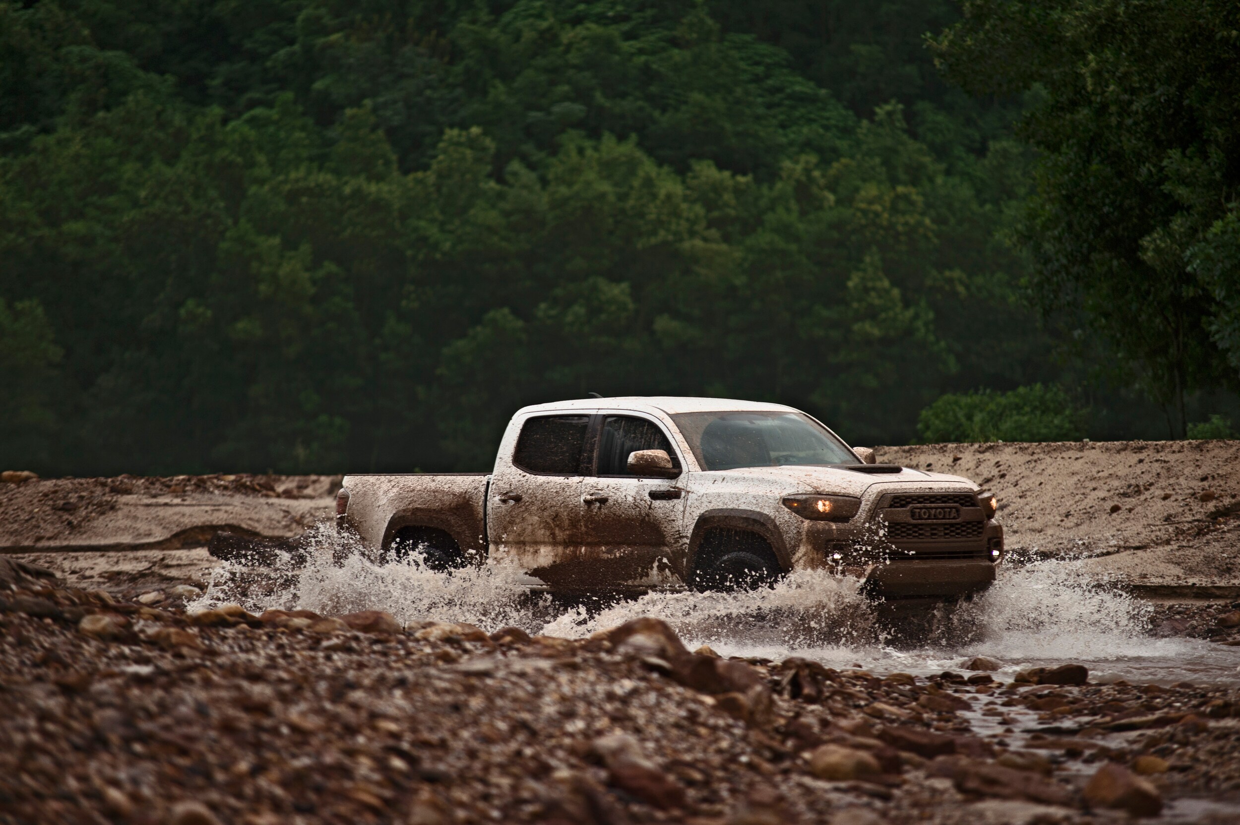 2018 Toyota Tacoma off-roading in a small, muddy creek