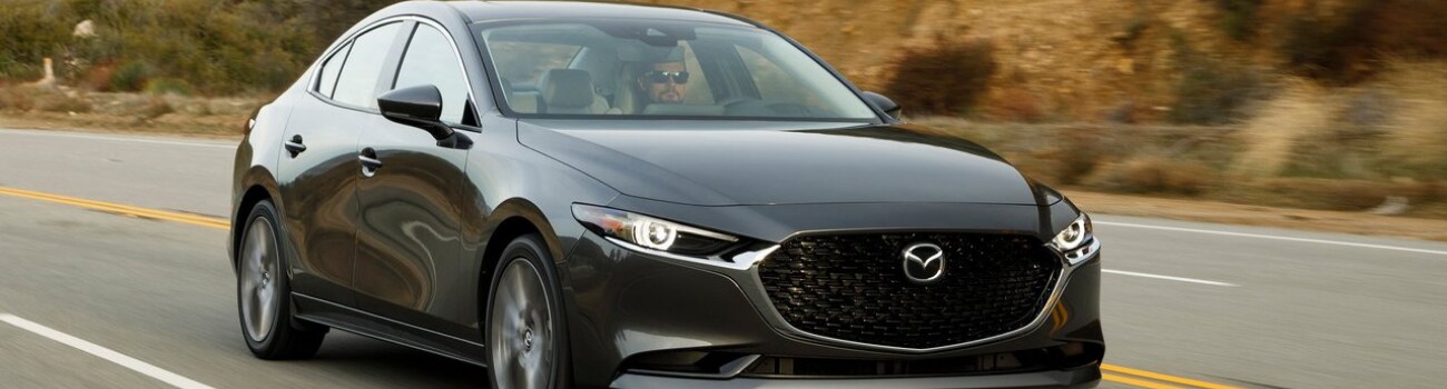 2019 Mazda3 configurations Bob Penkhus Mazda Motor City Colorado Springs.png Exterior view of a gray 2019 Mazda3 sedan driving down an open highway