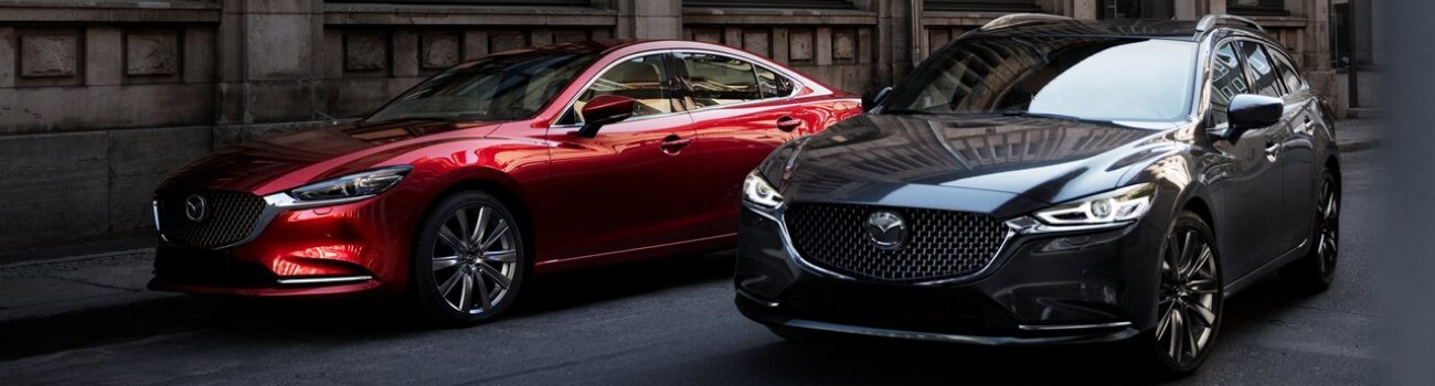 2019 Mazda6 Sedan Configurations Colorado Springs Bob Penkhus Mazda Powers.png Two different 2019 Mazda6 configurations in leaving their street parking spots in a downtown city scene