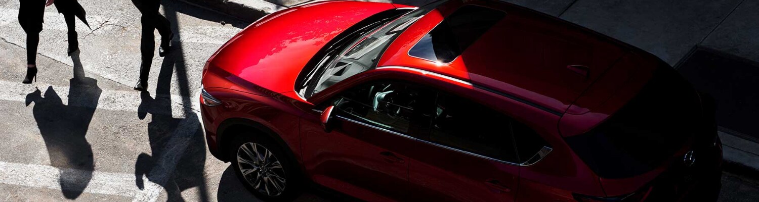 2019 Mazda CX-5 Sport Bob Penkhus Mazda at Powers Colorado Springs .png Aerial view of a red 2019 Mazda Sport as people walk past on a city crosswalk