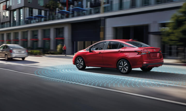 2020 Nissan Versa in red driving on a street showing saftey sensors .jpg
