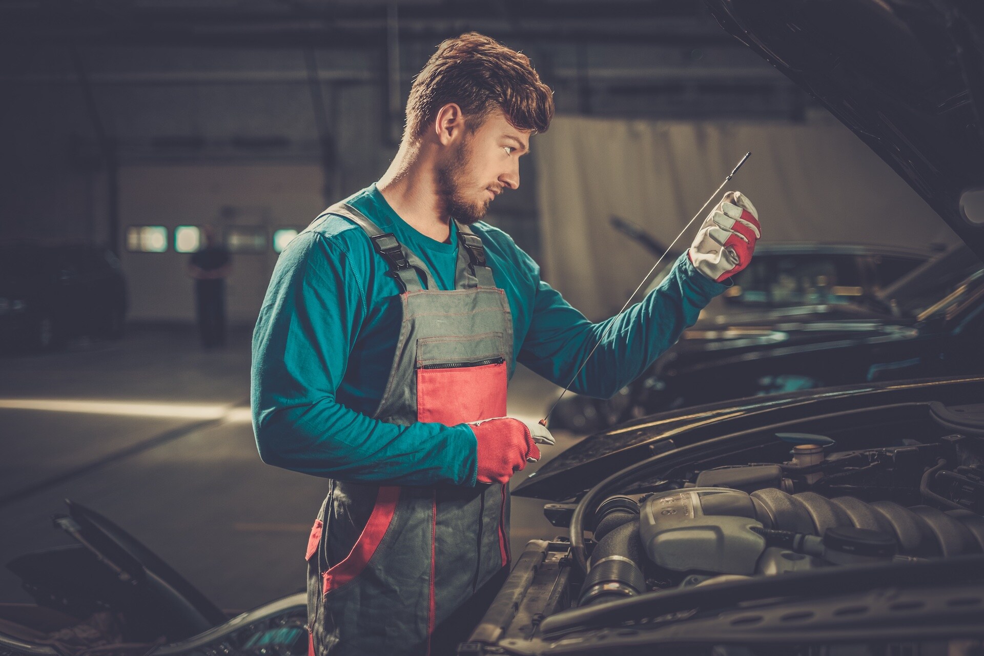 Difference between synthetic oil & conventional oil at Boch Auto | Mechanic checking oil level in car