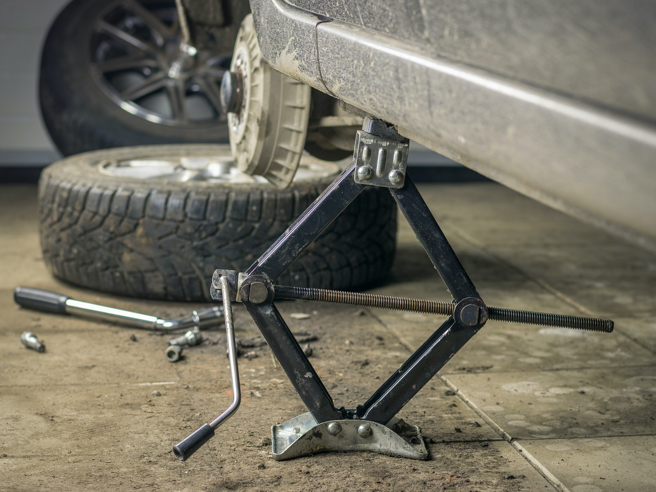 How to rotate your vehicle tires at Boch Auto Group in Massachusetts | Closeup of car rasied by jack
