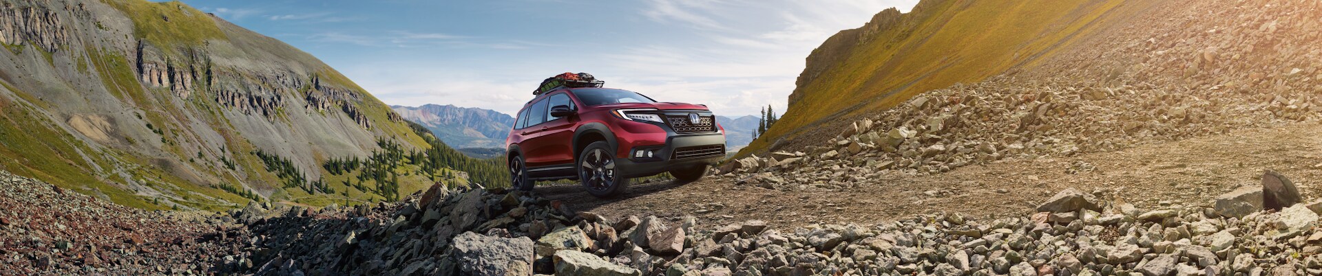 Boch Honda West is a Family Owned Dealership near Boxborough, MA | Red 2020 Honda Passport driving on rocks