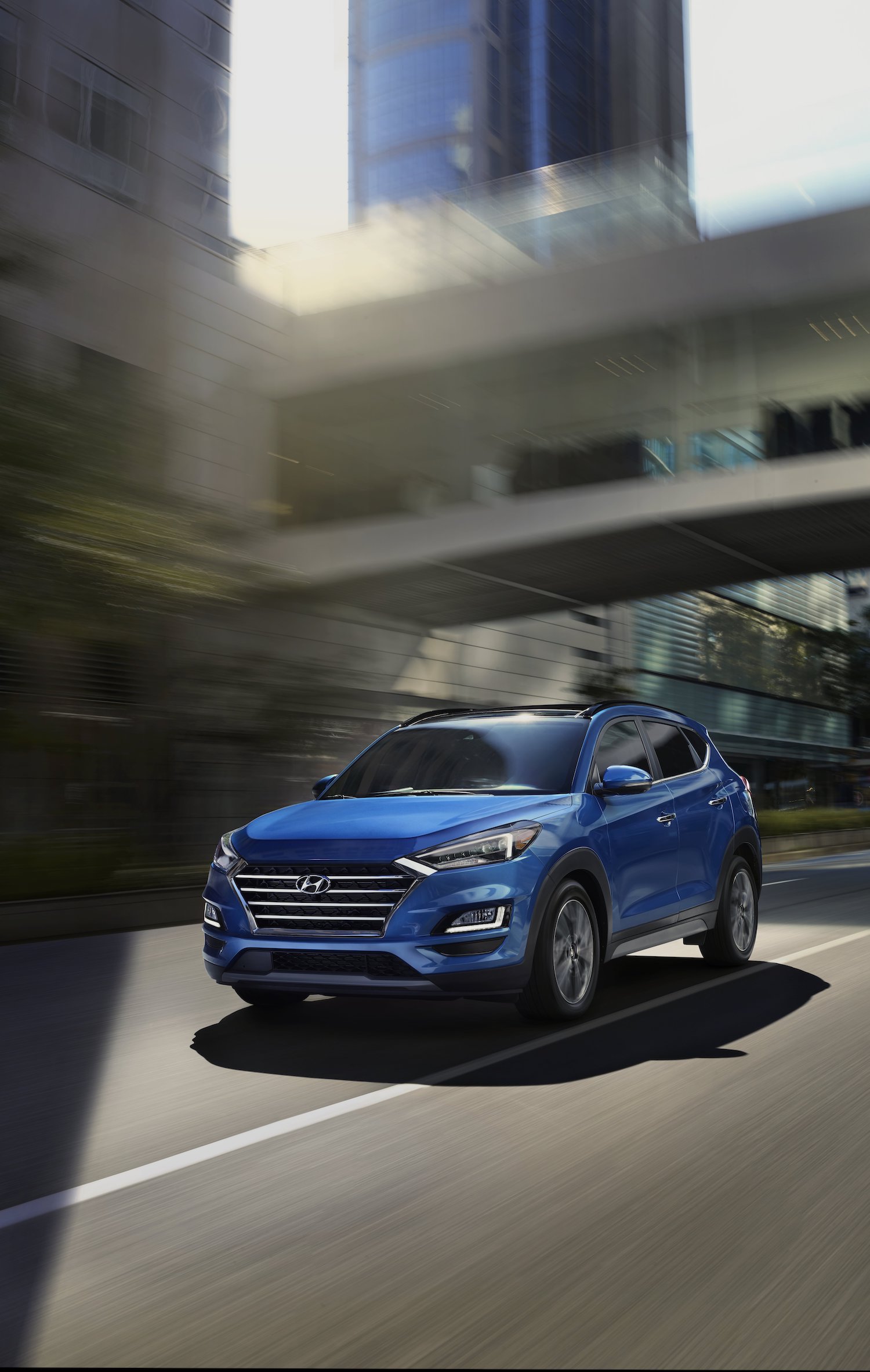 Blue hyundai tucson running on road Blue hyundai tucson running on road