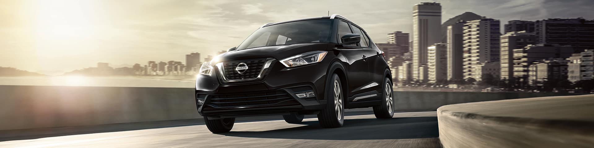 Boch Nissan South is a Family Owned Dealership near Foxborough, MA | 2020 Nissan Kicks driving with city in background