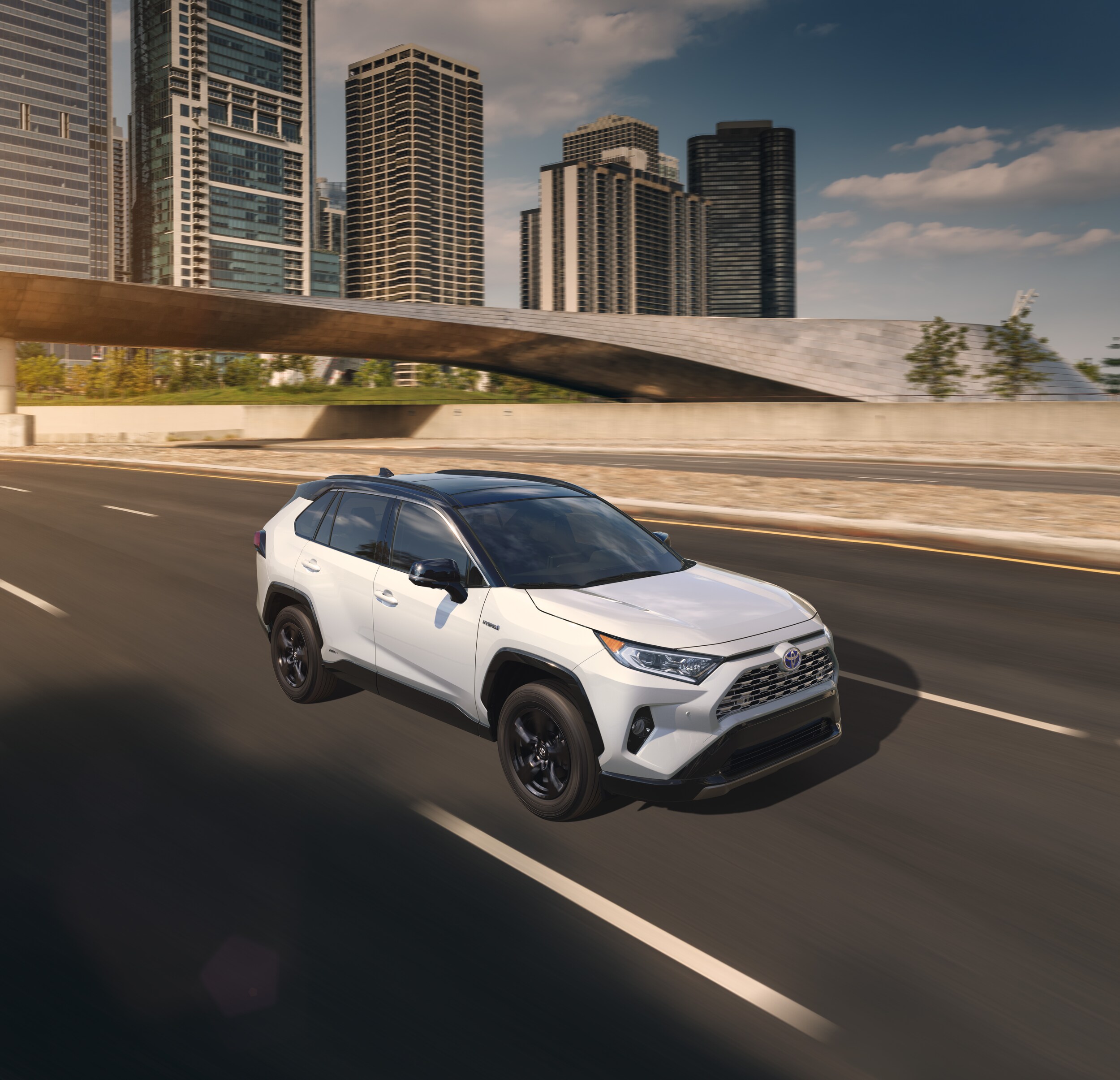 Boch Toyota is a Family Owned Dealership near Boston, MA | 2020 Toyota RAV4 driving on road with city visible in background