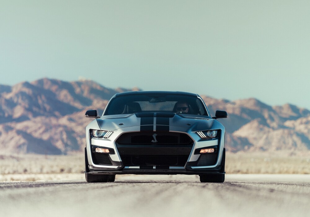 2020-ford-mustang-gt500-bowen-scarff-ford-dealership-near-seattle-washington.jpg A fierce, front facing, silver 2020 Shelby Mustang GT500 parked on a desert road with pink and purple mountains behind it.